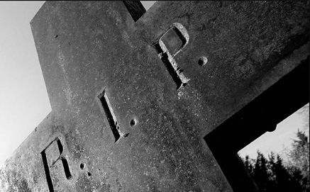 Close up of cross tombstone with RIP